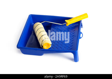 Rullo di vernice con un manico di colore giallo in una cuvetta di blu. Isolato su sfondo bianco. Foto Stock
