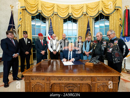 Presidente Trump , unite da Veterans Affairs Segretario Robert Wilke, sinistra e gli ospiti invitati segni S. 693 National POW/mia bandiera atto Giovedì, nov. 7, 2019, nell'Ufficio Ovale della Casa Bianca. Foto Stock