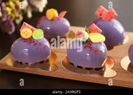 In casa mousse luminoso torte "cuori' con specchio viola ciliegina su uno sfondo scuro, orientamento orizzontale Foto Stock