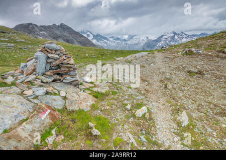 Pila di rocce, segnavia lungo il sentiero che porta ai ghiacciai e montagne coperte di neve. Kofler Vedi sentiero escursionistico delle Alpi italiane. Foto Stock