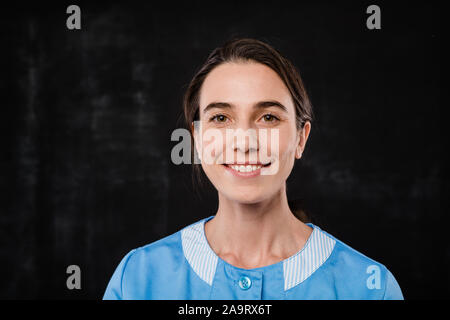 Piuttosto giovani hotel servizio in camera Servizio personale in uniforme in piedi nella parte anteriore della fotocamera Foto Stock