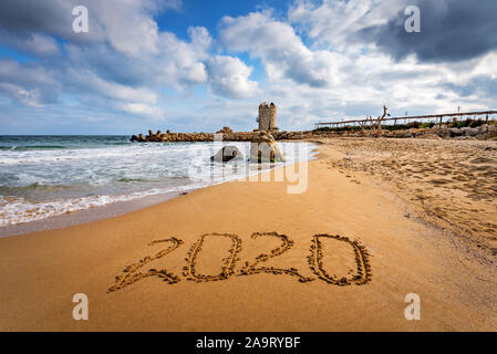 Numero 2020 scritta sulla spiaggia di sabbia a sunrise. Concetto di prossimo nuovo anno e passare del tempo. Foto Stock