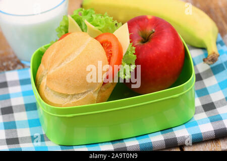 Scuola di sano lunchbox contenente il rotolo con formaggio, lattuga e pomodoro, Rosso mela e banana Foto Stock