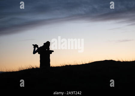 Silhouette al tramonto in cima cockleroy, bathgate colline Foto Stock