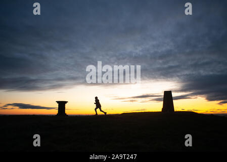 Silhouette al tramonto in cima cockleroy, bathgate colline Foto Stock