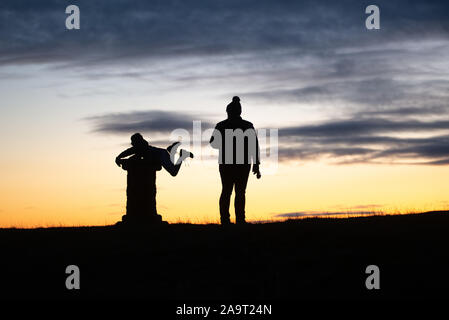 Silhouette al tramonto in cima cockleroy, bathgate colline Foto Stock