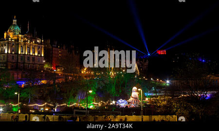 Edimburgo, Scozia, Regno Unito. 17 novembre 2019. Un occupato prima giornata intera a Princes Street Gardens Mercatino di Natale per finire con la luce notte dove essi interruttore albero di Natale luci su in cima al mucchio. Foto Stock