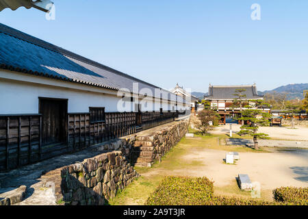 Il castello di Hiroshima. Il Ninomaru cortile con il tamonyagura, lungo la torre, che conduce al cancello anteriore, un yaguramon, gate con la torretta sopra. Blue sky. Foto Stock