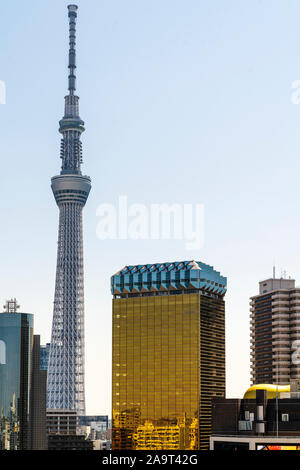 Distante shot della torre Skytree visto dal Tempio di Asakusa a Tokyo con la birra Asahi headquarters, AKA Asahi Beer hall in primo piano. Blu cielo chiaro Foto Stock