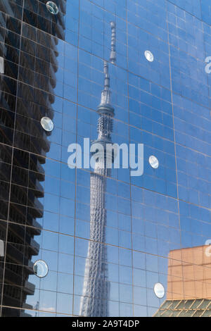 La Tokyo Skytree visualizzati in nero riflettente erba facciata della fabbrica di birra Asahi building. Pannelli di vetro dare effetto disarticolata alla skytree. Foto Stock