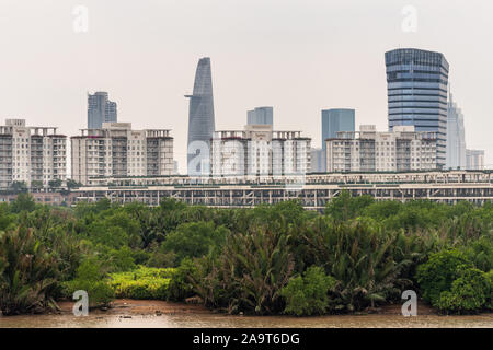 Ho Chi Minh City Vietnam - Marzo 12, 2019: canzone Sai Gon river. Bitexco torre finanziaria con lo skydeck sorge alle spalle di edifici di appartamenti di una Loi Dong n Foto Stock