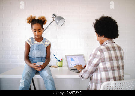 Occupato a lavorare la madre di non avere tempo per il suo bambino Foto Stock