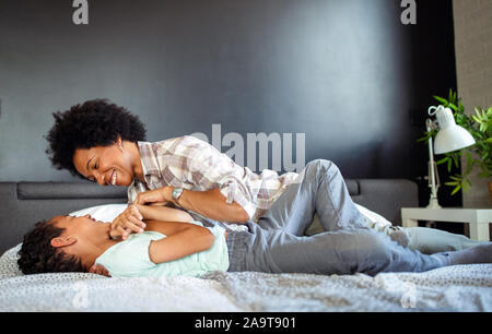 Felice madre giocare, divertirsi, abbracciando con suo figlio a casa Foto Stock