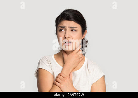 Malati sconvolto ragazza indiana toccando il collo, che soffrono di mal di gola Foto Stock