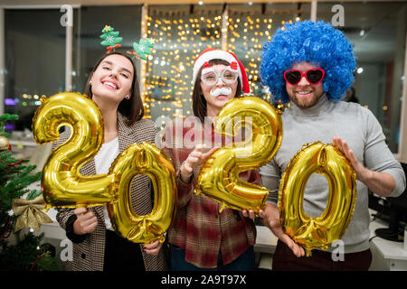 Allegro colleghi con numeri gonfiabile in piedi nella parte anteriore della fotocamera Foto Stock