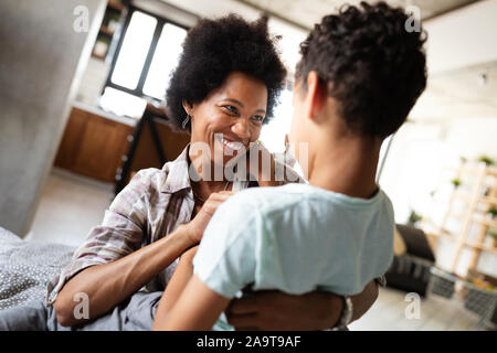 Felice madre giocare, divertirsi, abbracciando con suo figlio a casa Foto Stock