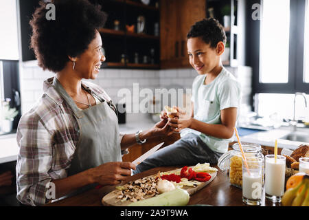 La madre e il bambino divertirsi la preparazione di un alimento sano in cucina Foto Stock