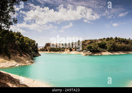 Vista del paesaggio di un bellissimo lago blu circondato da alberi sotto un nuvoloso cielo estivo Foto Stock