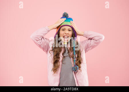 Preparazione per l'inverno. disgustato bambino sfondo rosa. kid fashion e shopping. ragazza. autunno stile. infanzia felice. piccola ragazza inverno hat. pronto per l'attività invernale. vestiti caldi per la stagione fredda. Foto Stock