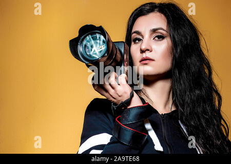 Ritratto di una bella bruna ragazza fotografo con lunghi capelli ricci Foto Stock