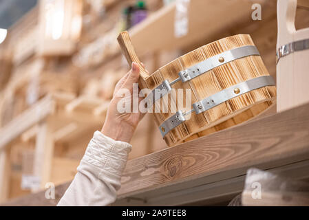 Donna di acquistare una nuova casa da bagno cucchiaio di legno per acqua vicino. Foto Stock