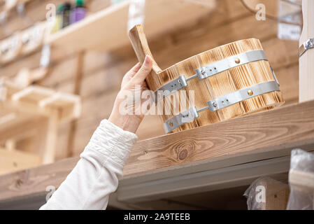 Donna di acquistare una nuova casa da bagno cucchiaio di legno per acqua vicino. Foto Stock