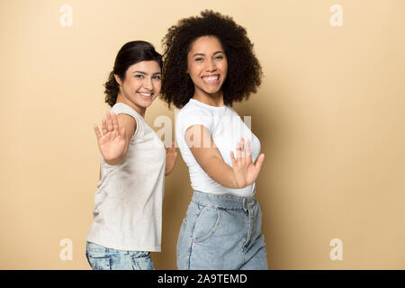 Sorridente diverse belle ragazze che ballano, in piedi con le braccia aperte Foto Stock