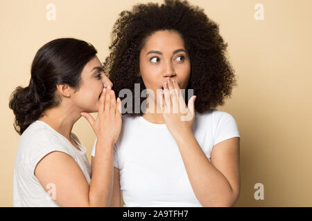 Ragazza indiana raccontando segreto per sorpreso storditi amico close up Foto Stock
