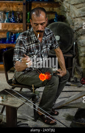 Uomo Glassblowing glassblower lavorando nel suo studio workshop vicino alla moschea Ibrahimi, in Cisgiordania città di Hebron, Palestina Foto Stock