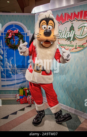 Carattere Goofy vestito come Santa a incontrare e salutare Foto Stock