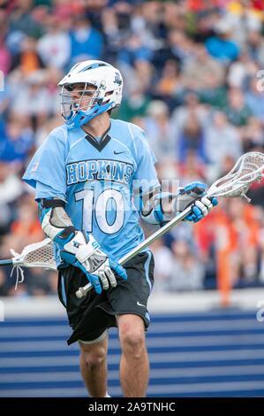 A tutta lunghezza shot di un helmeted Johns Hopkins University uomini Lacrosse player, che si sposta attraverso il campo con la sfera nella sua rete durante una associazione atletica collegiale nazionale quarti di finale corrisponde con l'Università della Virginia, 17 maggio 2009. Dall'Homewood raccolta di fotografie. () Foto Stock