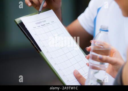 Piano di fitness. Istruttore sportivo ammonta al piano di allenamento close-up Foto Stock