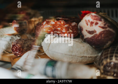 Prosciutto affumicato e vari prodotti a base di carne in esposizione in un negozio gourmet Foto Stock