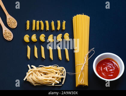 Forme diverse di pasta e spaghetti su sfondo nero. Foto Stock