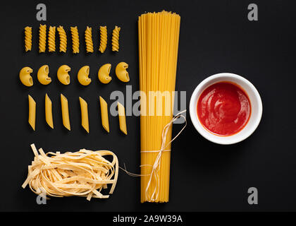 Forme diverse di pasta e spaghetti su sfondo nero. Foto Stock