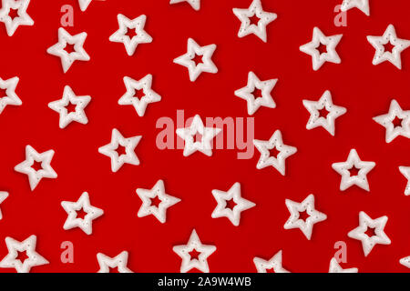 Molte stelle bianche su un brillante sfondo rosso. Modello di decorazioni di Natale Foto Stock