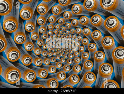 Batterie alcaline AA metallico arancione la parte superiore della batteria consente di visualizzare su sfondo blu. Modello a spirale Foto Stock