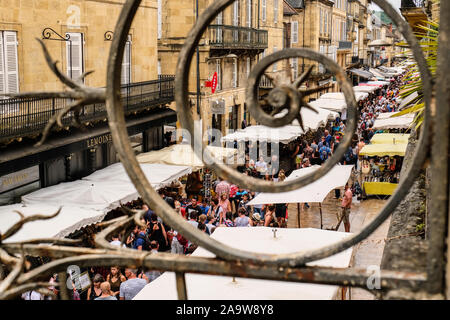 Mercato degli Agricoltori visto attraverso la cancellata in ferro battuto a Sarlat, Francia Foto Stock