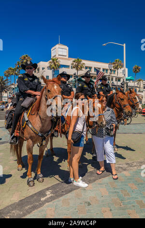 Huntington Beach, Stati Uniti d'America - Luglio 03, 2017: Equestre degli ufficiali di polizia da Huntington Beach e Santa Ana i dipartimenti di polizia di interagire con i turisti Foto Stock