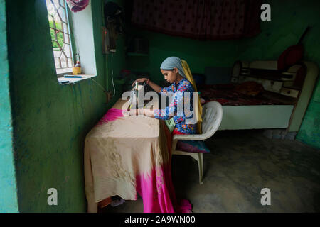 Ragazza giovane con cucitura a macchina da cucire Foto Stock