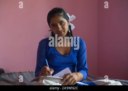 School girl iscritto nel suo notebook Foto Stock