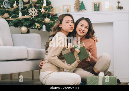 Due amiche asiatica lo scambio di regali di natale Foto Stock