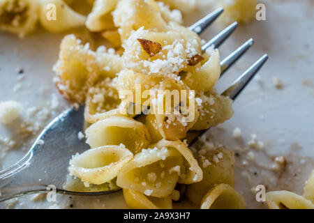 Macro Vista ravvicinata del guscio di pasta Conchiglie / Conchiglioni sulla forcella con parmigiano e noce. I cibi tradizionali. Foto Stock