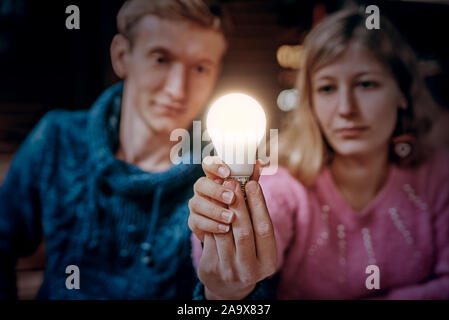 L uomo e la donna in possesso di una lampada incandescente nelle loro mani. concetto di sogni e idee Foto Stock