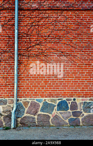 Parte iniziale su un mattone rosso con il muro di pietra naturale fondamento. Foto Stock