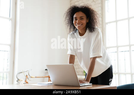 African American business giovane donna appoggiata sulla tavola. Foto Stock
