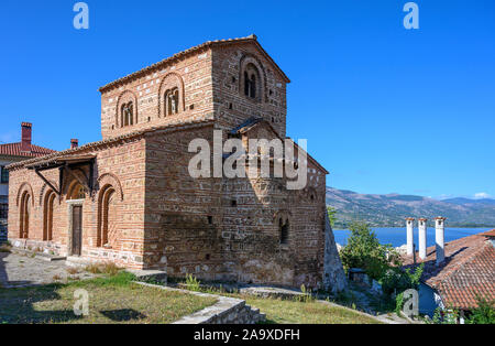 Il dodicesimo cen. La chiesa bizantina di Agii Anargiri in Kastoria, con il lago Orestiada in background, Macedonia, Grecia settentrionale Foto Stock