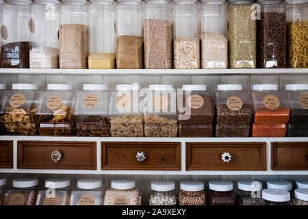 Close up di ripiani con una selezione di pasta, legumi e cereali in vasetti di vetro. Foto Stock