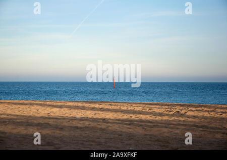 Pomeriggio soave luce sulla spiaggia di Brighton in Gran Bretagna. Polo rossa visibile nell'acqua. Foto Stock