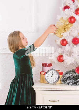 Bambino festeggiano il Natale a casa. Giorno preferito dell'anno. Celebrazione della Messa di Natale. Ottenere incredibilmente entusiasti di natale. Kid ragazza albero di natale in attesa della mezzanotte orologio. Infanzia felicità concetto. Foto Stock